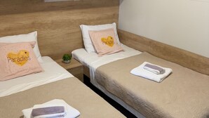 Two single beds with beige bedding, a small potted plant, and a folded towel on each bed. - Mobile Home Paradise (Sveti Filip i Jakov)