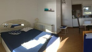 Ein Schlafzimmer mit einem Bett, einem Nachttisch und einem kleinen Schreibtisch mit Stuhl.