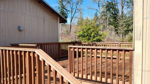A wooden deck with a ramp leading to a building. - Charming 2-bedroom farmhouse in Willamina's relaxing countryside. (Willamina)