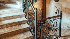 A staircase with ornate metal railings and wooden steps. - Kallista Cappadocia (Nevsehir)