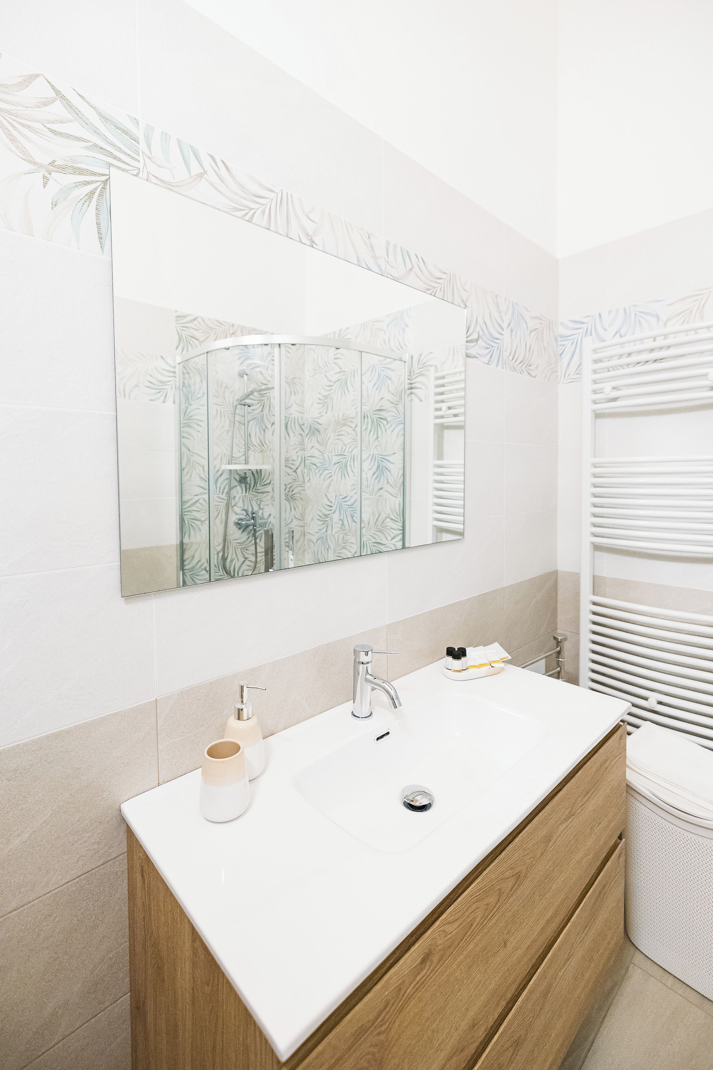 Un bagno con un ampio specchio, un lavabo doppio e un portasciugamani.