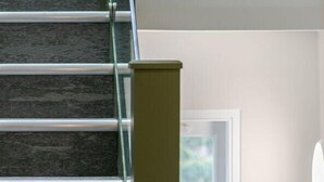 A staircase with a handrail, a window with a view of greenery, and a wall with a light switch. - Journeys Kings Cross - Hostel (London)