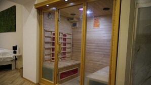 A sauna room with wooden walls, a bench, and a glass door. - Bellosguardo Suites (San Paolo Bel Sito)