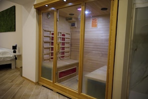 Un sauna avec des murs en bois, un banc et une porte en verre.