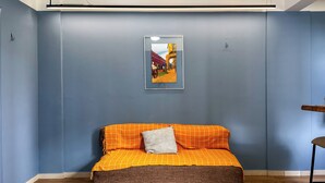 A bedroom with a bed, a framed picture on the wall, and a wooden floor. - Modern loft in Belém with solar energy - At Doca Umarizal - downtown (Belém)