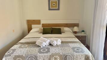 2 dormitorios, tabla de planchar con plancha, ropa de cama