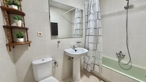 A bathroom with a toilet, sink, shower, and a mirror. - Las Amapolas Apartment - 12018 (Ajo)