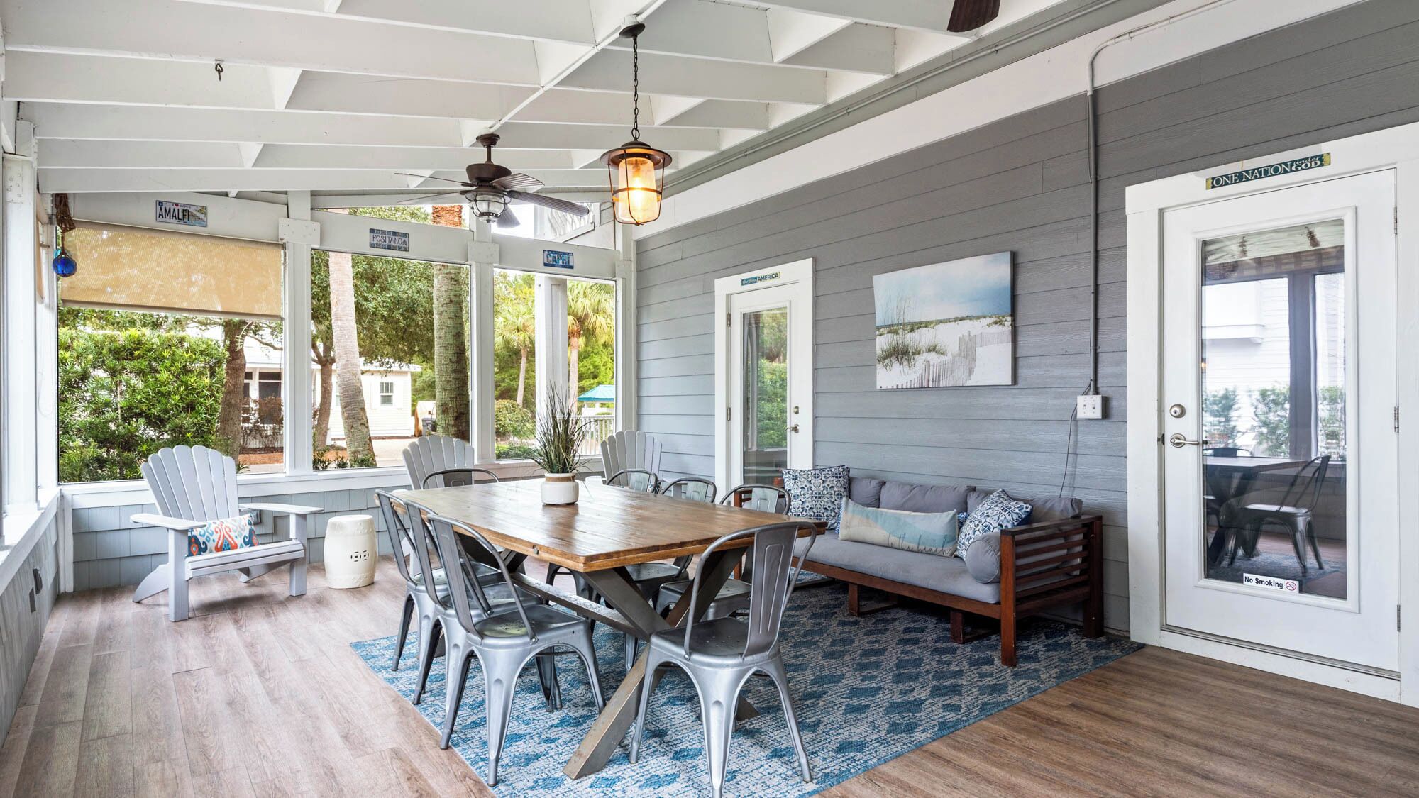 A covered patio with a dining table, chairs, and a sofa.