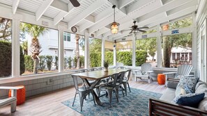 A sunroom with a dining table, chairs, a sofa, and a ceiling fan. - Newly Updated 5BR Home in Blue Mountain - Sleeps 12 (Santa Rosa Beach)