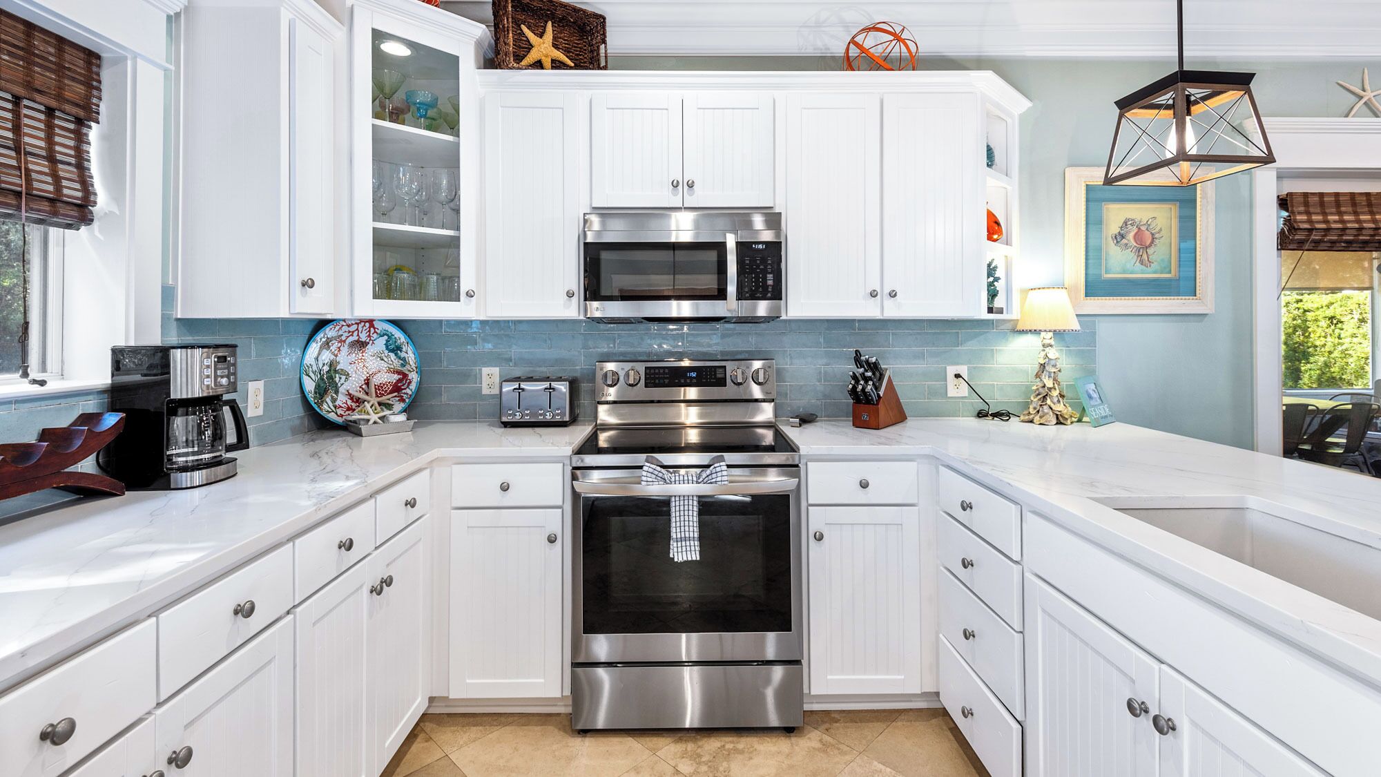 A kitchen with white cabinetry, a stainless steel oven, a microwave, and a toaster.