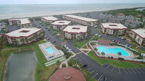 Ein Resort mit mehreren Gebäuden, einem Swimmingpool und Blick auf den Strand.