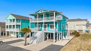A multi-story building with balconies and a staircase leading to the upper levels. - 4 Bedroom 3 Bath walking distance to everything + hot tub! (Holden Beach)