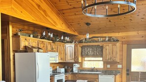 Interior de madera con cocina, comedor y asientos.