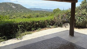 A covered outdoor area with a view of a green landscape and mountains. - Charming house in a green setting, between scrubland and sea (Zonza)