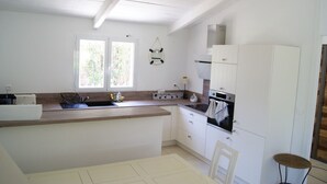 A kitchen with white cabinets, a wooden countertop, a sink, and a stove. - Charming house in a green setting, between scrubland and sea (Zonza)