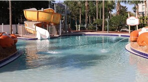 En swimmingpool med en vattenrutschkana och en skylt som visar vilka regler som gäller vid poolen.