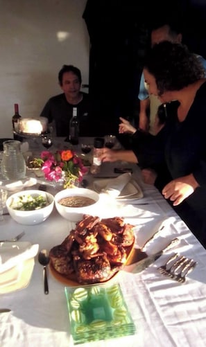 Uma mesa de jantar com comida, copos de vinho e uma garrafa.