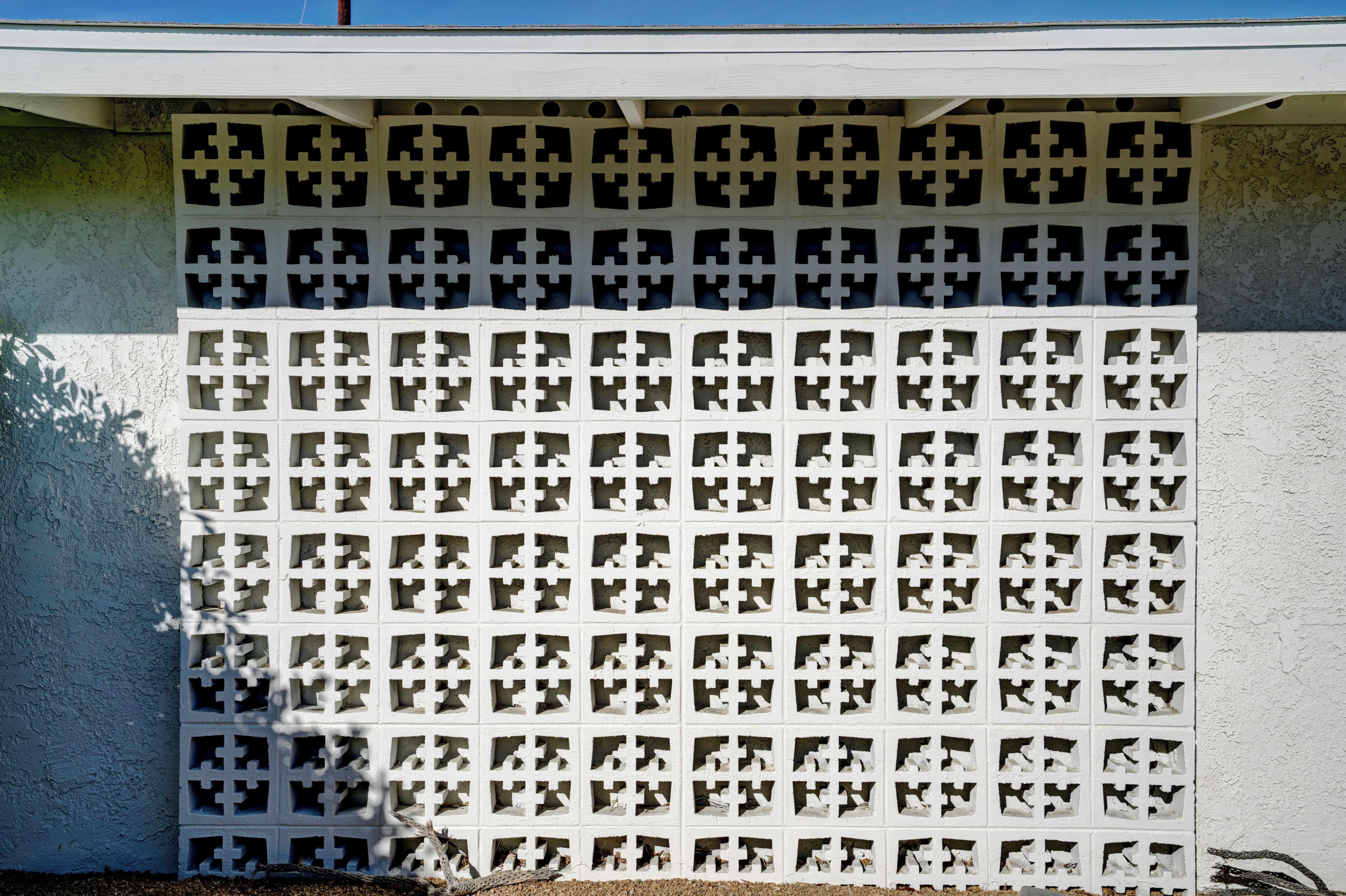 A white wall with a grid of square openings.