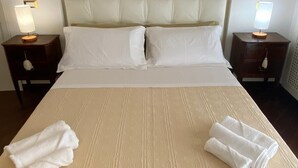 Ett hotellrum med en stor säng, två sängbord med lampor och en sänggavel.