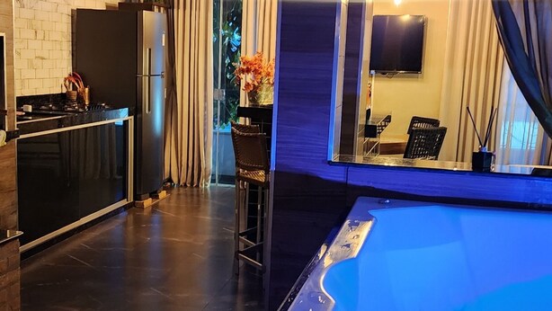 Ein modernes Wohnzimmer mit einer großen Badewanne, einer Küchenzeile und einem Essbereich.