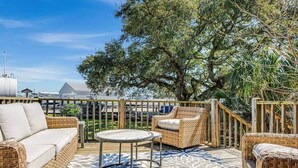 An outdoor patio with wicker furniture, a round table, and a patterned floor.