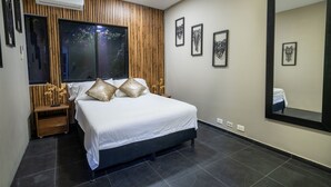 Ein modernes Schlafzimmer mit einem großen Bett, Holzvertäfelung, einem großen Spiegel und Kunstwerken an den Wänden.