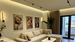 Ein modernes Wohnzimmer mit einer Couch, einem Couchtisch und Kunstwerken an der Wand.
