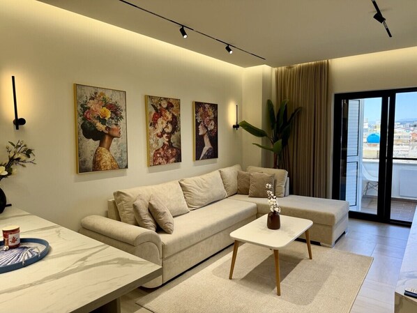 A modern living room with a sofa, a coffee table, and artwork on the wall.