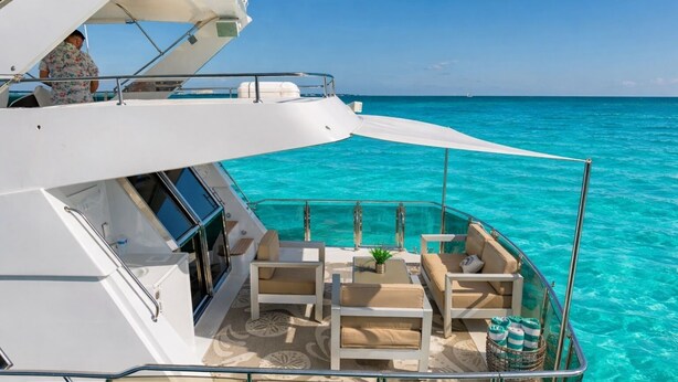 Eine Yacht mit Sonnendeck, ausgestattet mit einer Sitzecke, einem kleinen Tisch und einem Blumentopf.
