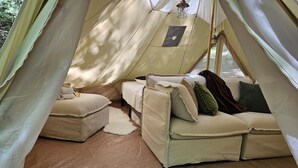 A tent with a bed, a sofa, and a small table. - Whisper "Hollar" | Secluded Luxe Glamping Retreat (Turtletown)
