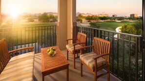 A balcony with wooden furniture and a table with apples, overlooking a golf course and buildings. - Discover Desert Luxury at The Westin Kierland Villas - 1 Bedroom Premium Villa (Scottsdale)