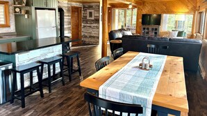 Interior de una cabaña con cocina, comedor y sala de estar.