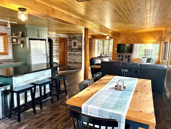 Interior de una cabaña con cocina, comedor y sala de estar.