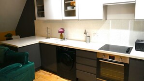 A compact kitchen with a dishwasher, oven, and a small countertop. - Super Central 2 Bedroom Apartment Sleeps 5, 85` TV (Canterbury)