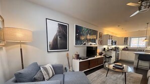 A modern living room with a grey sofa, a flat-screen TV, and artwork on the walls. - Soak, Sip, and Stay. Sonoma Retreat Near the Plaza (Sonoma)
