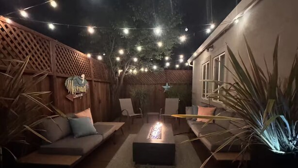 A patio with string lights, a fire pit, a wooden deck, and a lounge area with a sign. - Soak, Sip, and Stay. Sonoma Retreat Near the Plaza (Sonoma)