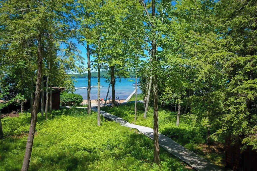 A pathway leading to a beach with trees and a clear view of the sea.