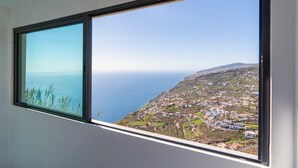 Une fenêtre donnant sur la côte, avec vue sur une ville et la mer.