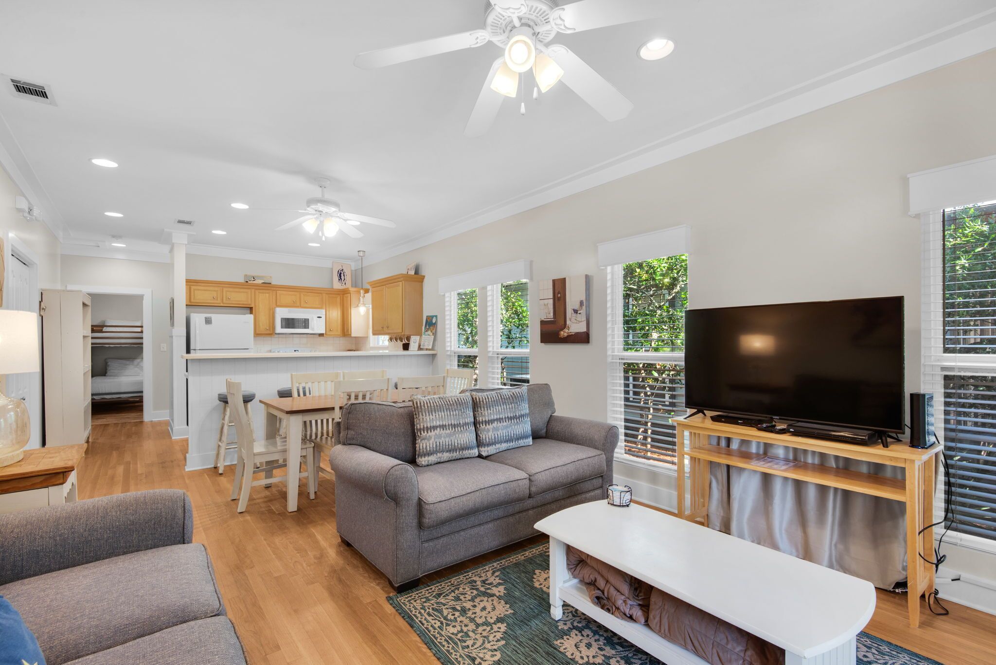 A modern living room with a sofa, TV, and dining area.