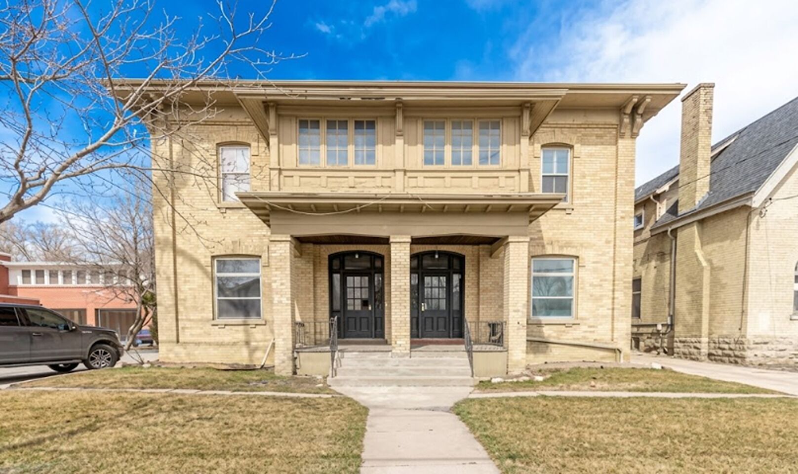 A two-story house with a front porch, a garage, and a driveway.