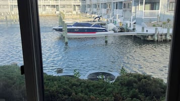 A view of a marina with a boat docked, surrounded by multi-story buildings with balconies.