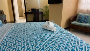 A hotel room with a large bed, a chair, a desk, and a TV on the wall. - Cozy 1-Bedroom Studio in the Heart of Enchanting Rodney Bay–Fully AirConditioned (Rodney Bay)