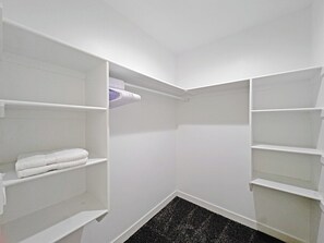 A walk-in closet with white shelving units and a black speckled floor. - Lehi Basement: 2 Kings, 4 Queens, Pool & Parks (Lehi)