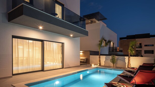 Uma casa moderna com piscina, varanda e área de pátio.