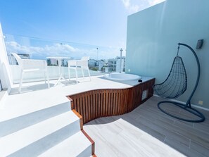 A rooftop terrace with a hot tub, white chairs, and a hanging chair. - Penthouse w/ Private Terrace & Tub | Rooftop Pool | Near Beach (Playa del Carmen)