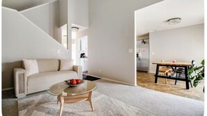 Una sala de estar moderna con sofá, mesa de centro y comedor.