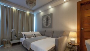 Un dormitorio moderno con cama, mesita de noche, lámpara y un adorno en la pared.