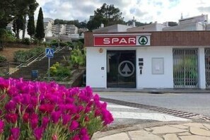 A building with a sign reading 'SPAR' and a pedestrian crossing sign.