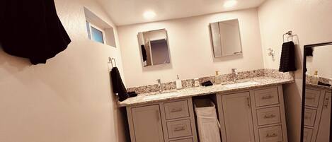 Une salle de bain comprenant des toilettes, un lavabo, un miroir et des placards.