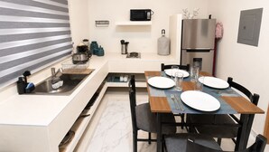 A compact kitchen with a microwave, sink, and refrigerator. - CABO DOWNTOWN STUDIOS: 2BR Queen apt fully equipped Downtown steps to marina (Cabo San Lucas)